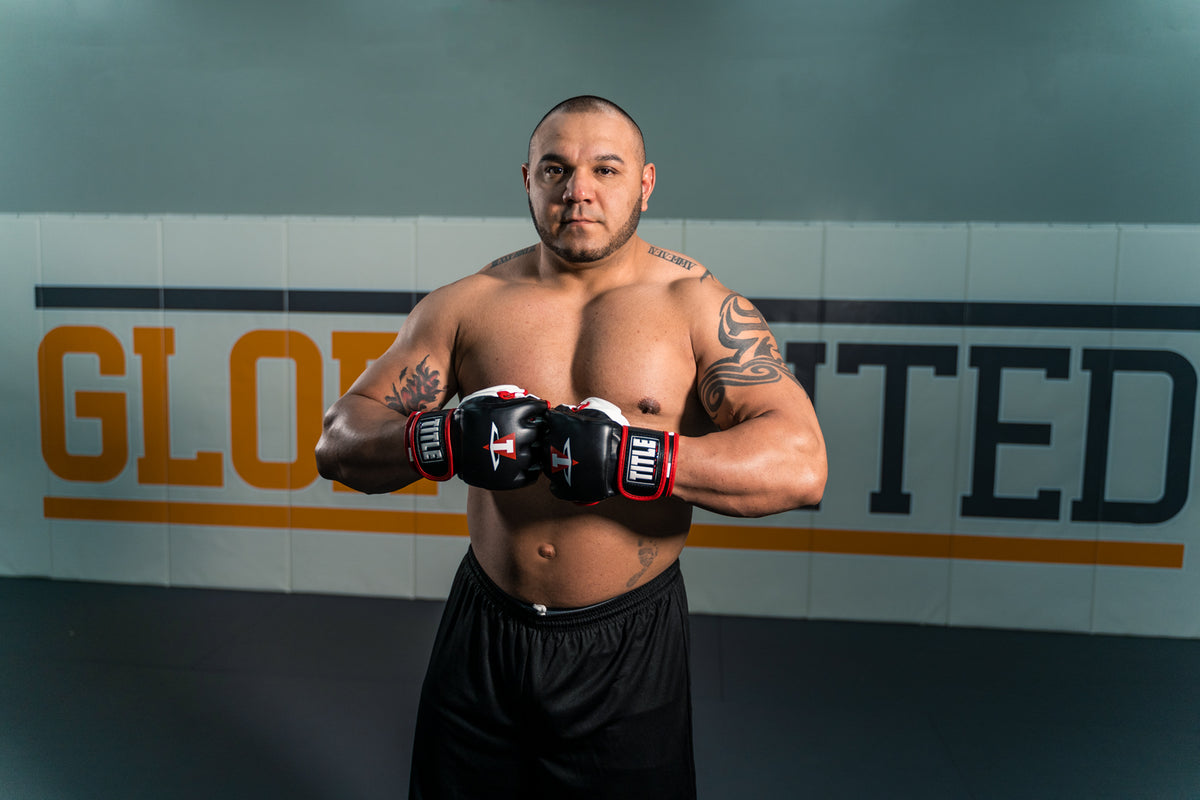 TITLE MMA Conflict Training Gloves man posing with training gloves