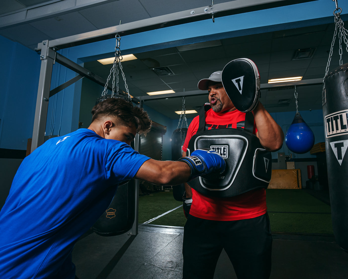 variant:lifestyle::TITLE Boxing Aerovent Elite Body Protector back view of kid hitting right jab