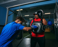 variant:lifestyle::TITLE Boxing Aerovent Elite Body Protector back view of kid hitting right jab