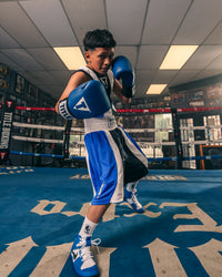 variant:blue::TITLE Boxing USA Boxing Competition Gloves - Elastic gloves on kid in ring