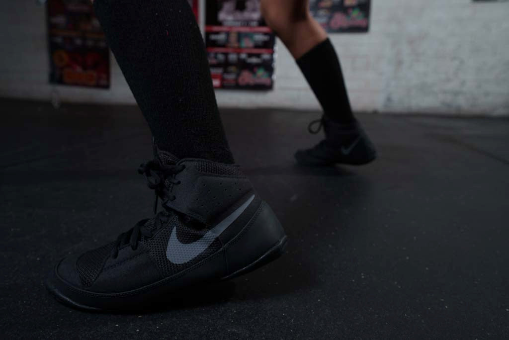 variant:Black/Silver::Nike Fury Boots  side view feet on floor