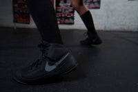 variant:Black/Silver::Nike Fury Boots  side view feet on floor