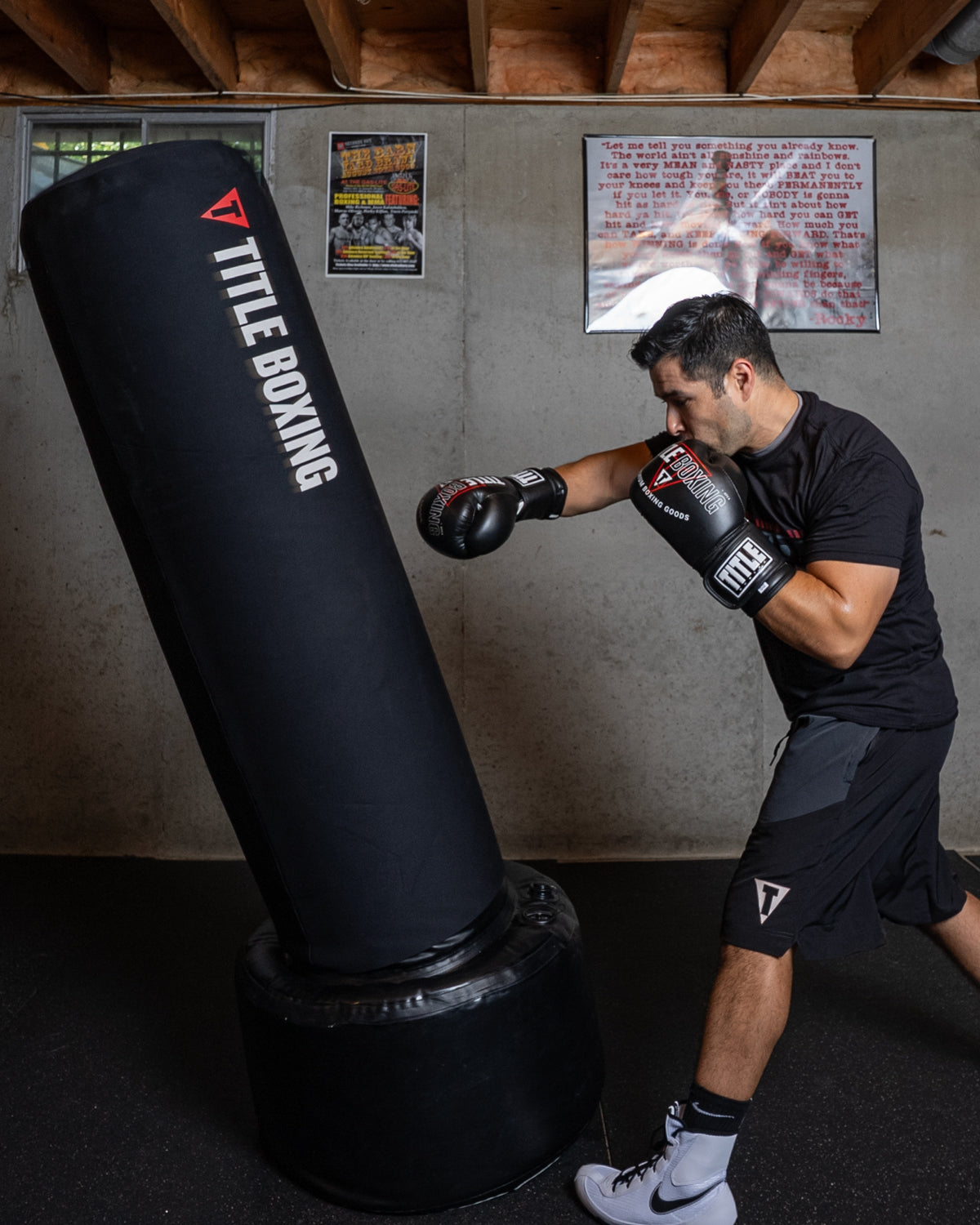 variant:black::TITLE Boxing AquaAir Freestanding Heavy Bag in action being punched by boxer
