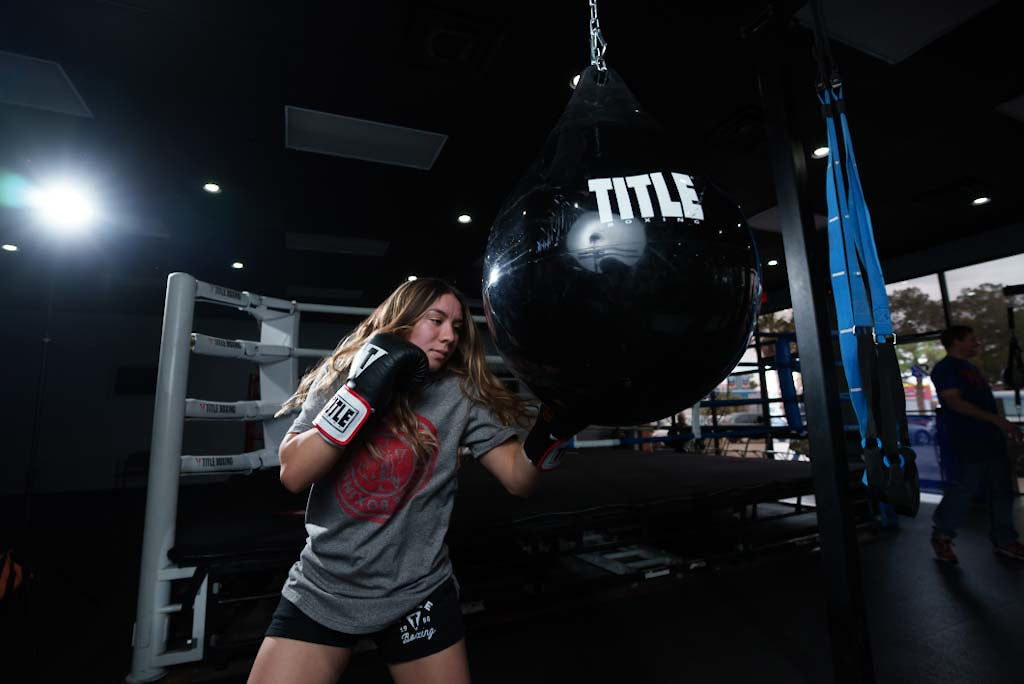 variant:lifestyle::TITLE Boxing Aqua Training Punch Bag girl hitting bag