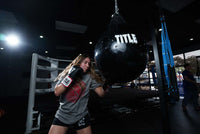 variant:lifestyle::TITLE Boxing Aqua Training Punch Bag girl hitting bag
