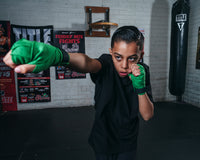 variant:lifestyle::TITLE Boxing Advanced Semi-Elastic Assorted Hand Wraps (10 Pair) green hand wraps on a young boxer