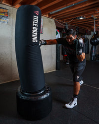 variant:black::TITLE Boxing AquaAir Freestanding Heavy Bag in action being punched by boxer