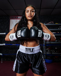 variant:Black/White/Gold::TITLE Boxeo Pro Fight Gloves girl in boxing stance