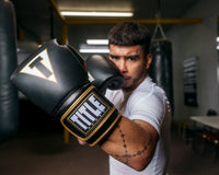 variant:black/white::TITLE Boxeo Mexican Leather Training Gloves Quatro guy standing 