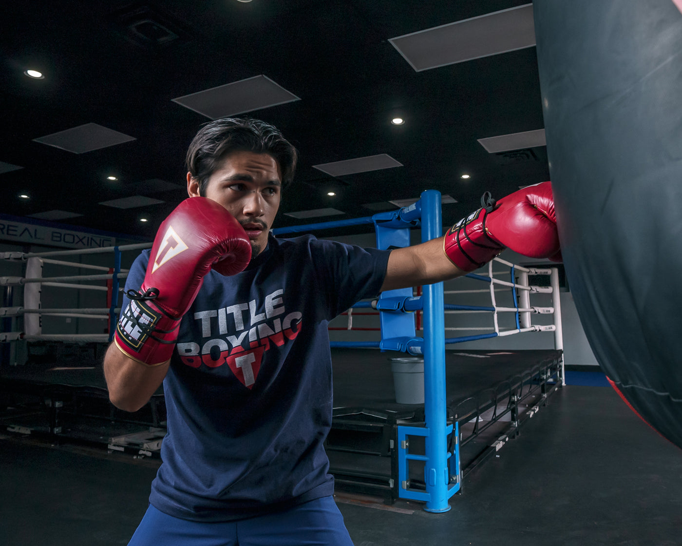 variant:red/white::TITLE Boxeo Mexican Leather Lace Training Gloves Quatro guy hitting bag