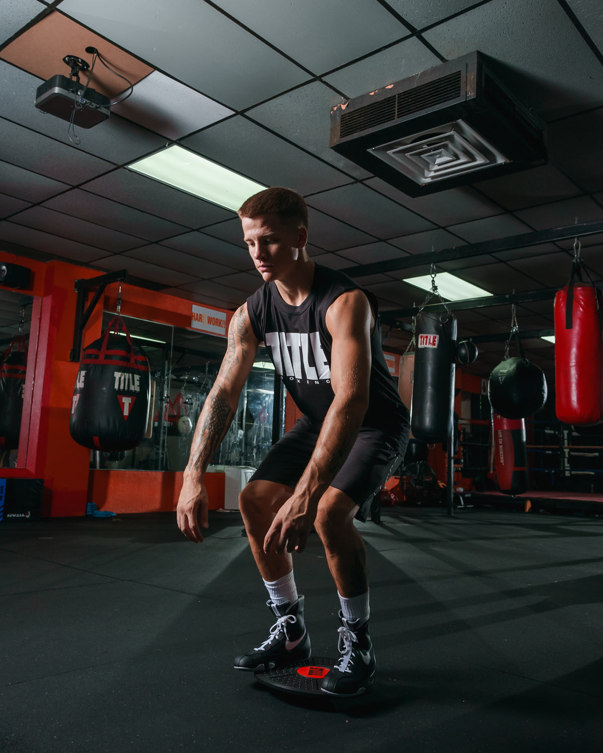 Man using TITLE Boxing Balance board for conditioning