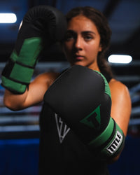 variant:Black/Green::TITLE Boxing Conquest Training Boxing Gloves closeup on boxer's hands in fighting stance