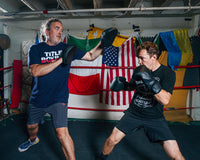 variant:lifestyle::TITLE Black Punch Mitts 2.0 coach and trainer mitting