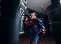 variant:lifestyle::TITLE Boxing Blood Red Leather Training Gloves kid hitting bag left hook