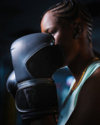 variant:grey::TITLE Boxing Ultra Bag Gloves closeup of glove on boxer's hand held near face