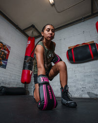 variant:black/pink::TITLE Classic Speed Boxing Gloves girl kneeling on ground