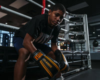 variant:black/gold::TITLE Classic Speed Boxing Gloves kid sitting on edge of ring