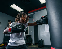 variant:lifestyle::TITLE Classic Black Max Boxing Gloves kid hitting bag left jab