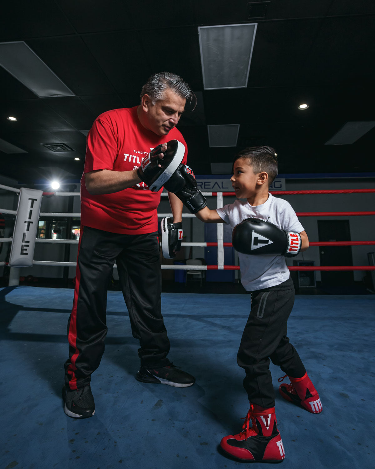 variant:lifestyle::TITLE Classic Black Max Boxing Gloves kid with trainer