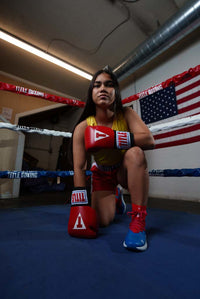 variant:red::TITLE Classic USA Boxing Competition Gloves girl kneeling on ring