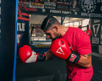 variant:lifestyle::TITLE Classic Power Weight Bag Gloves guy punching a bag