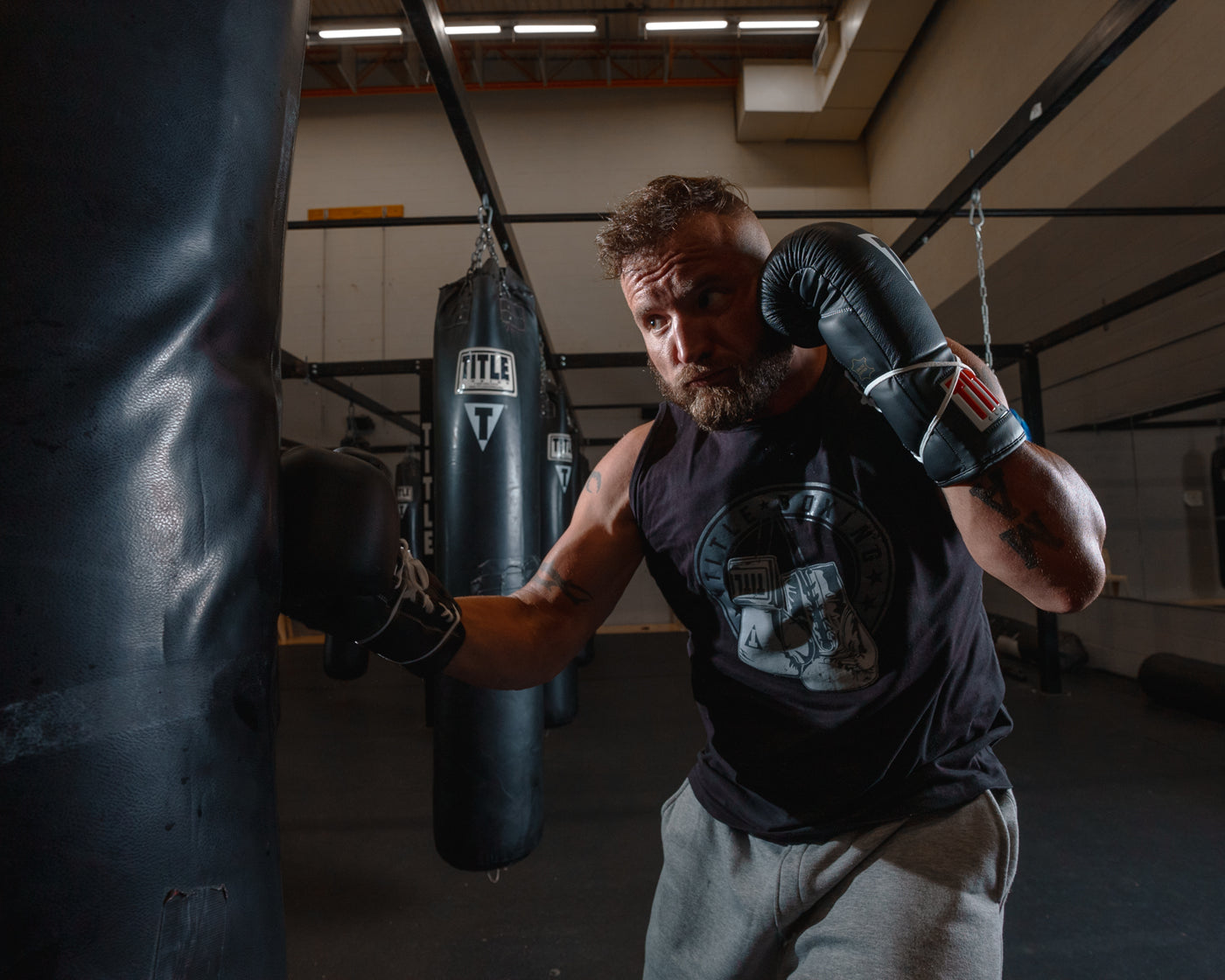 variant:black::TITLE Classic Leather Lace Training Gloves 2.0 guy hitting bag