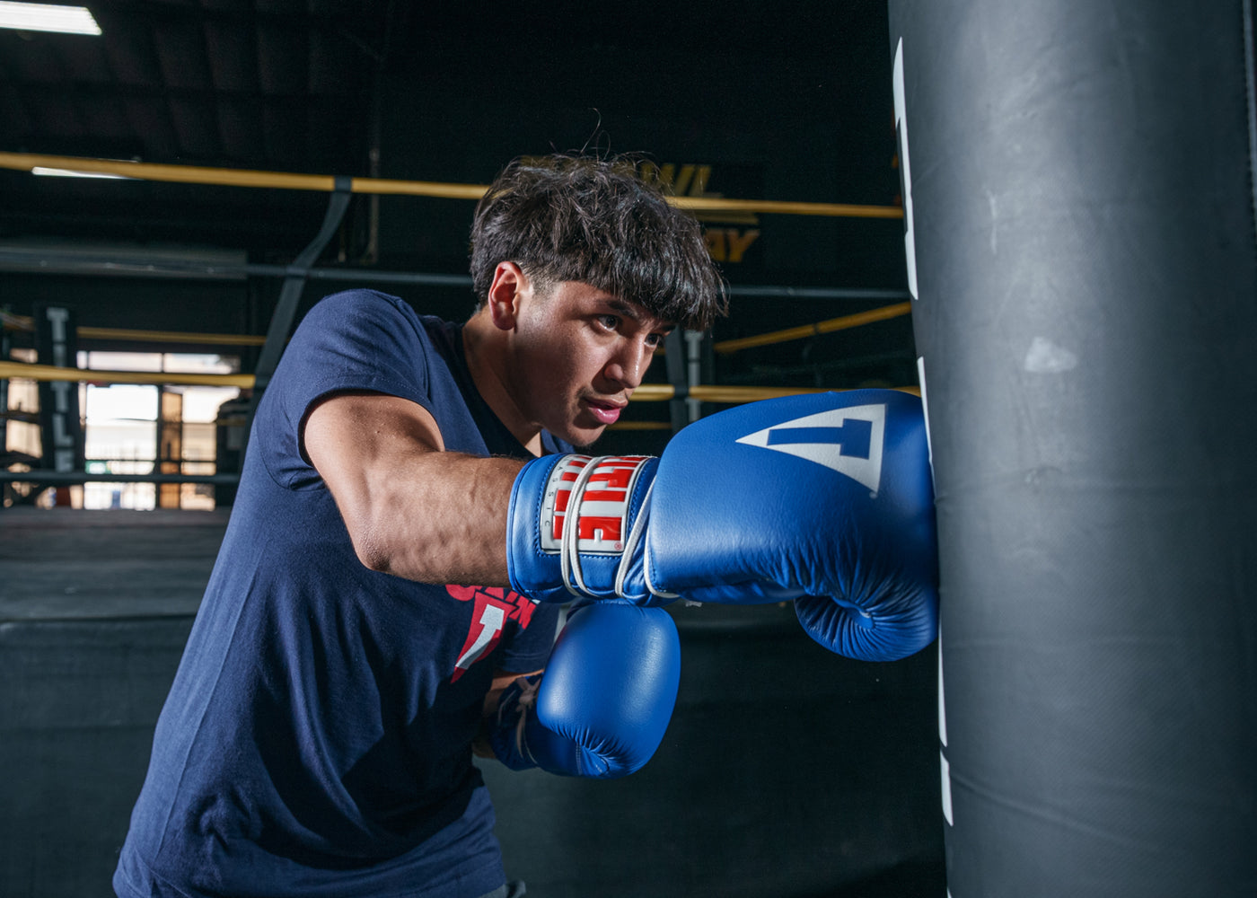 variant:blue::TITLE Classic Leather Lace Training Gloves 2.0 right jab on bag