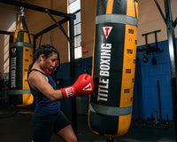 variant:red::TITLE Classic Leather Elastic Training Gloves guy holding gloves together