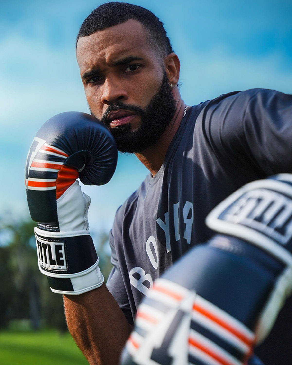 variant:Navy/White/Orange::TITLE Boxing World Bag Boxing Gloves on boxer's hands in fighting stance closeup