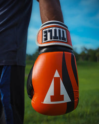 variant:Orange/Black/White::TITLE Boxing World Bag Boxing Gloves on boxer's hand closeup