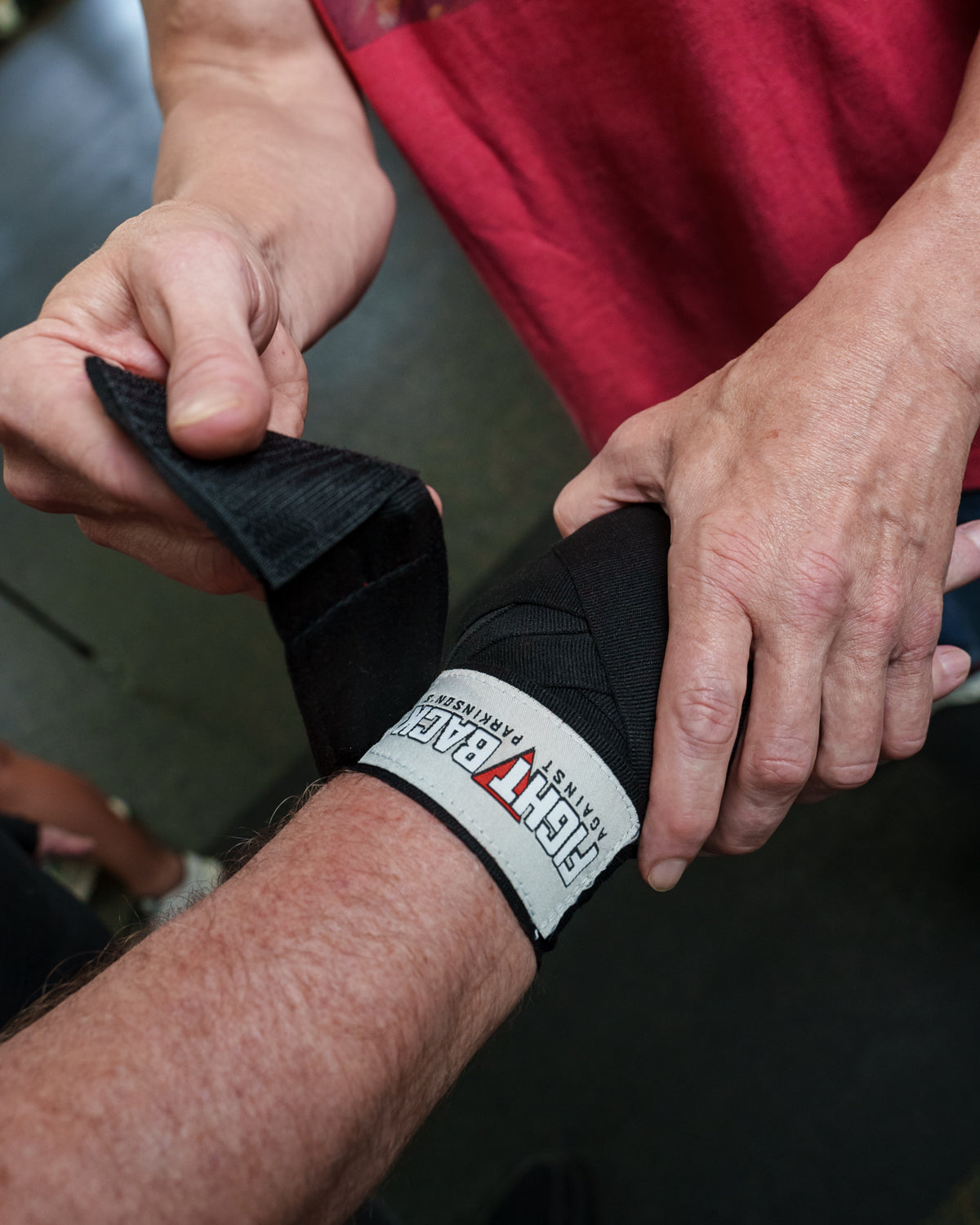 variant:black::TITLE Boxing Fight Back Semi-Elastic Hand Wraps wrapping hands