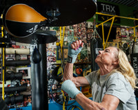 variant:Light Blue::TITLE Boxing Fight Back Semi-Elastic Hand Wraps hitting speed bag