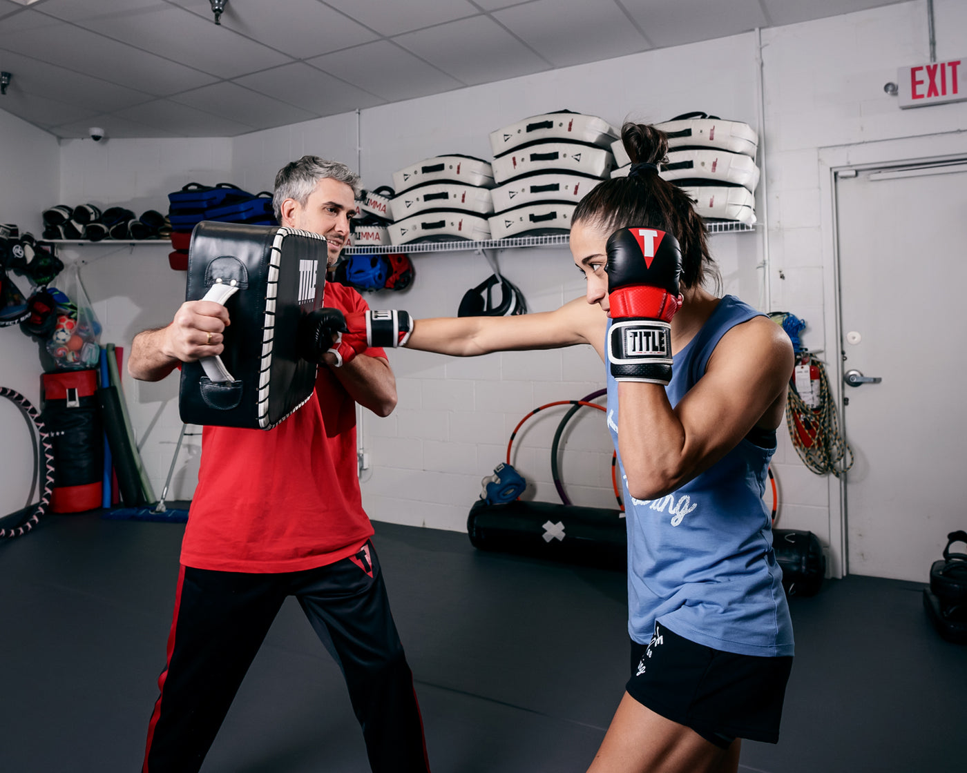 variant:lifestyle::TITLE MMA Full Contact Sparring Gloves girl hitting pad