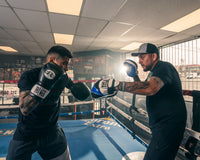 variant:lifestyle::TITLE Boxing Flurry Micro Pro Punch Mitts guy holding mitts for boxer