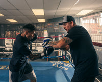 variant:lifestyle::TITLE Boxing Flurry Micro Pro Punch Mitts guy holding mitts for boxer side view