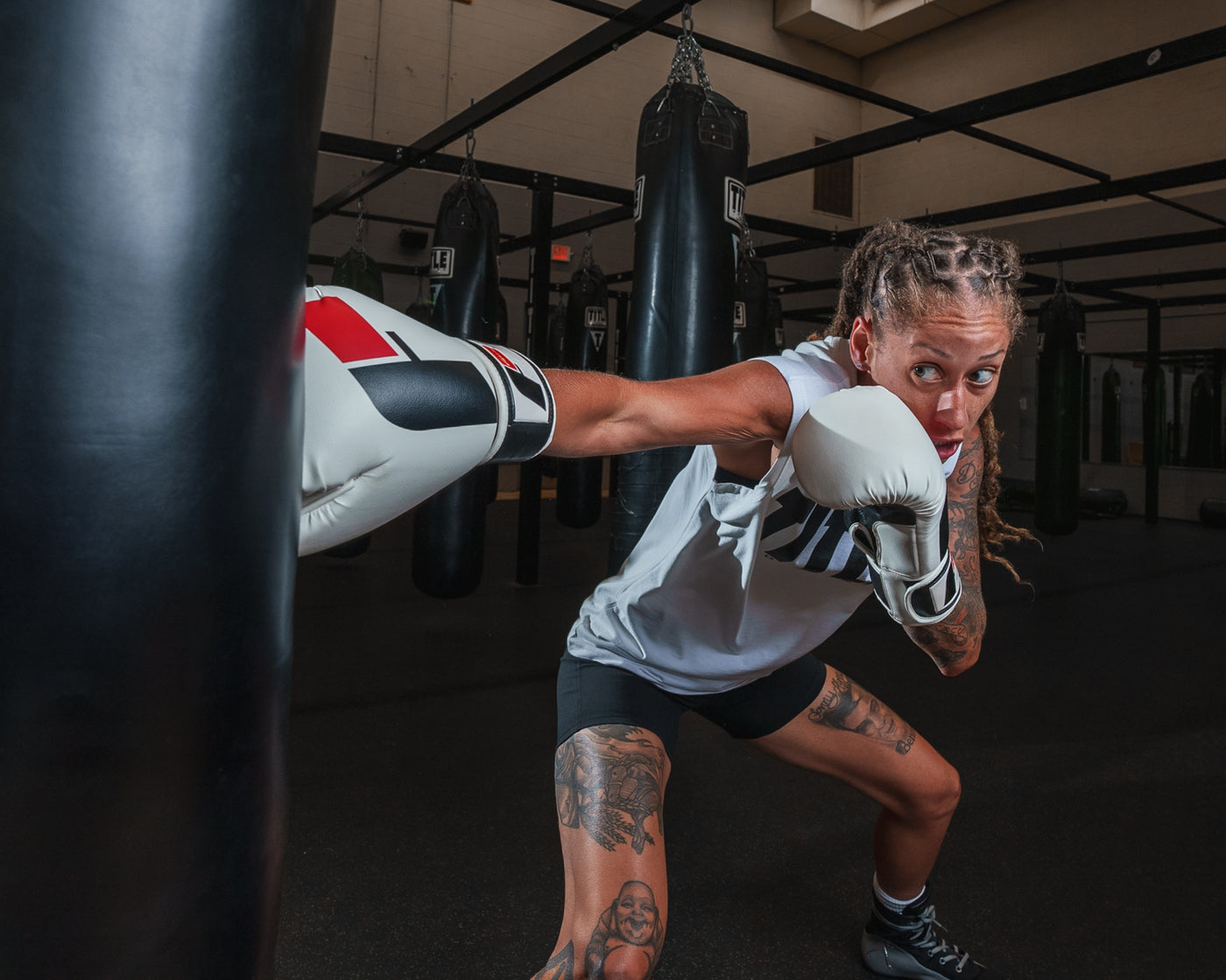 variant:White/Black::Fighting Sports Gloves and Wraps Bundle black/white gloves on fighter in the gym