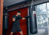 variant:black::Fighting Fury Professional Lace Training Gloves guy hitting bag