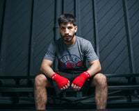 variant:Red::Fighting Semi-Elastic 180" Hand Wraps boy between hand wraps boxer sitting down