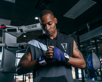 variant:blue/white::Fighting 180" Semi Elastic Hand Wraps guy looking down hands together