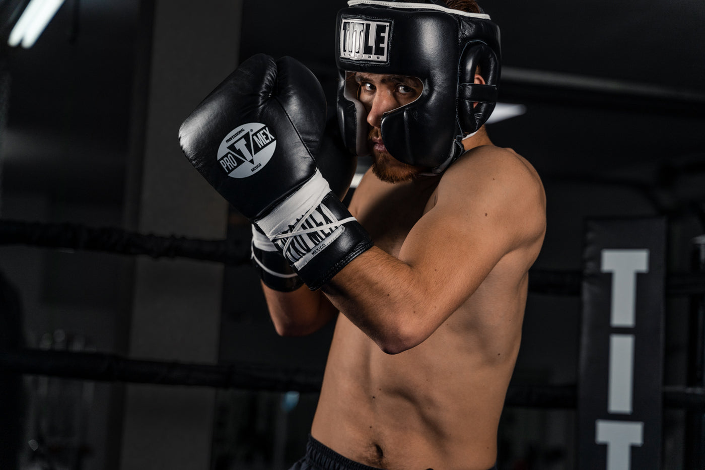 variant:Black::TITLE Boxing Headgear and Groin Protector Bundle closeup of headgear on fighter