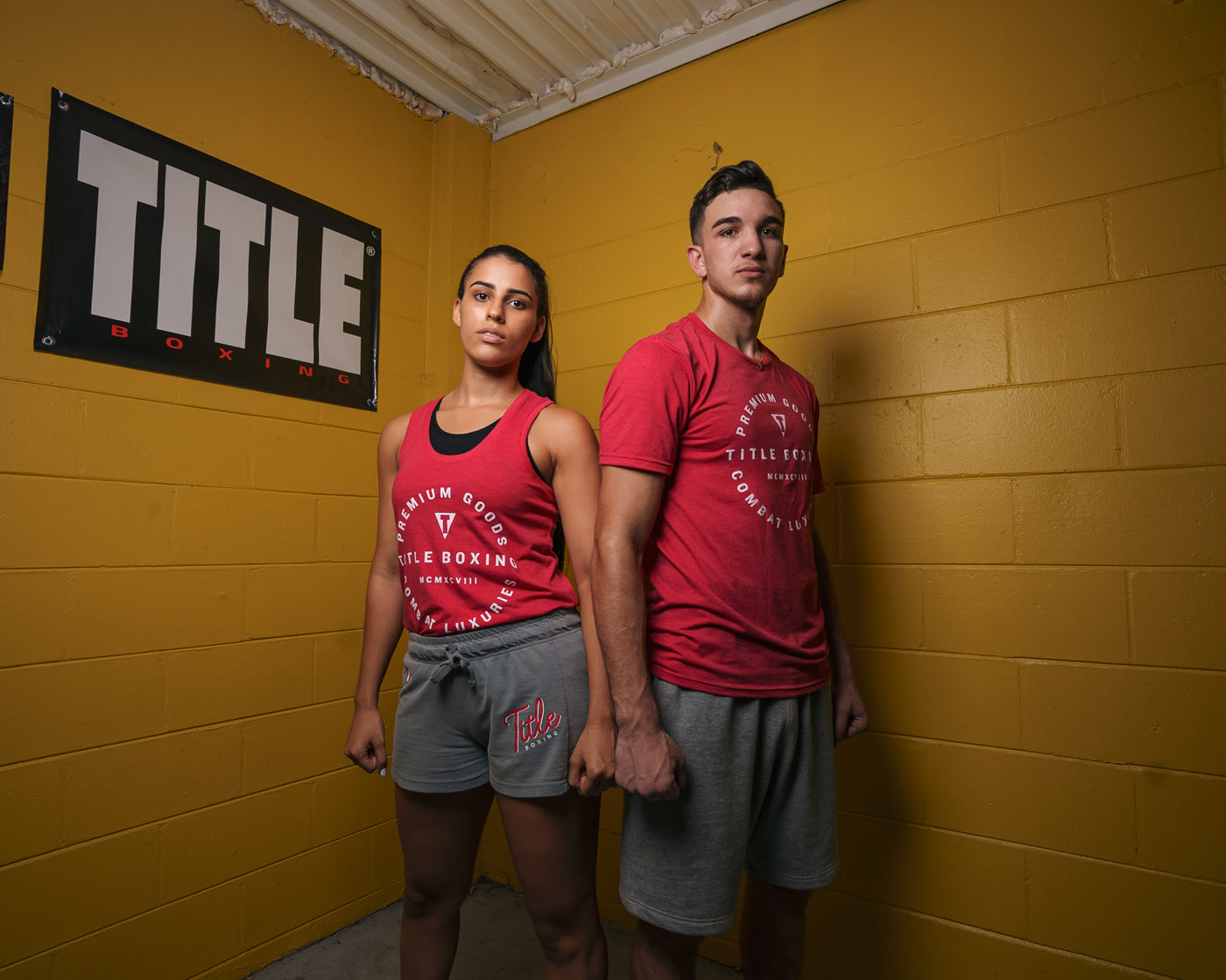 variant:lifestyle::TITLE Boxing Big Logo Banner on the wall of a gym behind two boxers