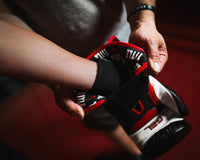 variant:lifestyle::TITLE Boxing Gel Generation Leather Bag Gloves being put on boxer's hands