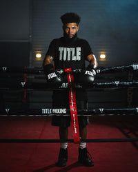 variant:lifestyle::TITLE Boxing Gel Generation Leather Lace Sparring Gloves on boxer leaning on ring ropes