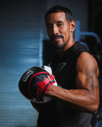 variant:lifestyle::TITLE Boxing Gel Leather Punch Mitts on fighter's hands side view