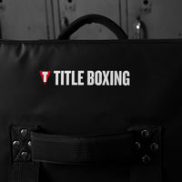 variant:lifestyle::TITLE Boxing Gel Ripple Strike Shield in gym closeup of back handles