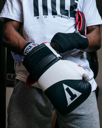 variant:Black/White::TITLE Boxing Gel Suspense Training Gloves putting on gloves