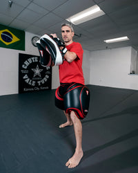 variant:lifestyle::TITLE MMA Gel Thai Style Thigh Pads 2.0 coach boxing stance