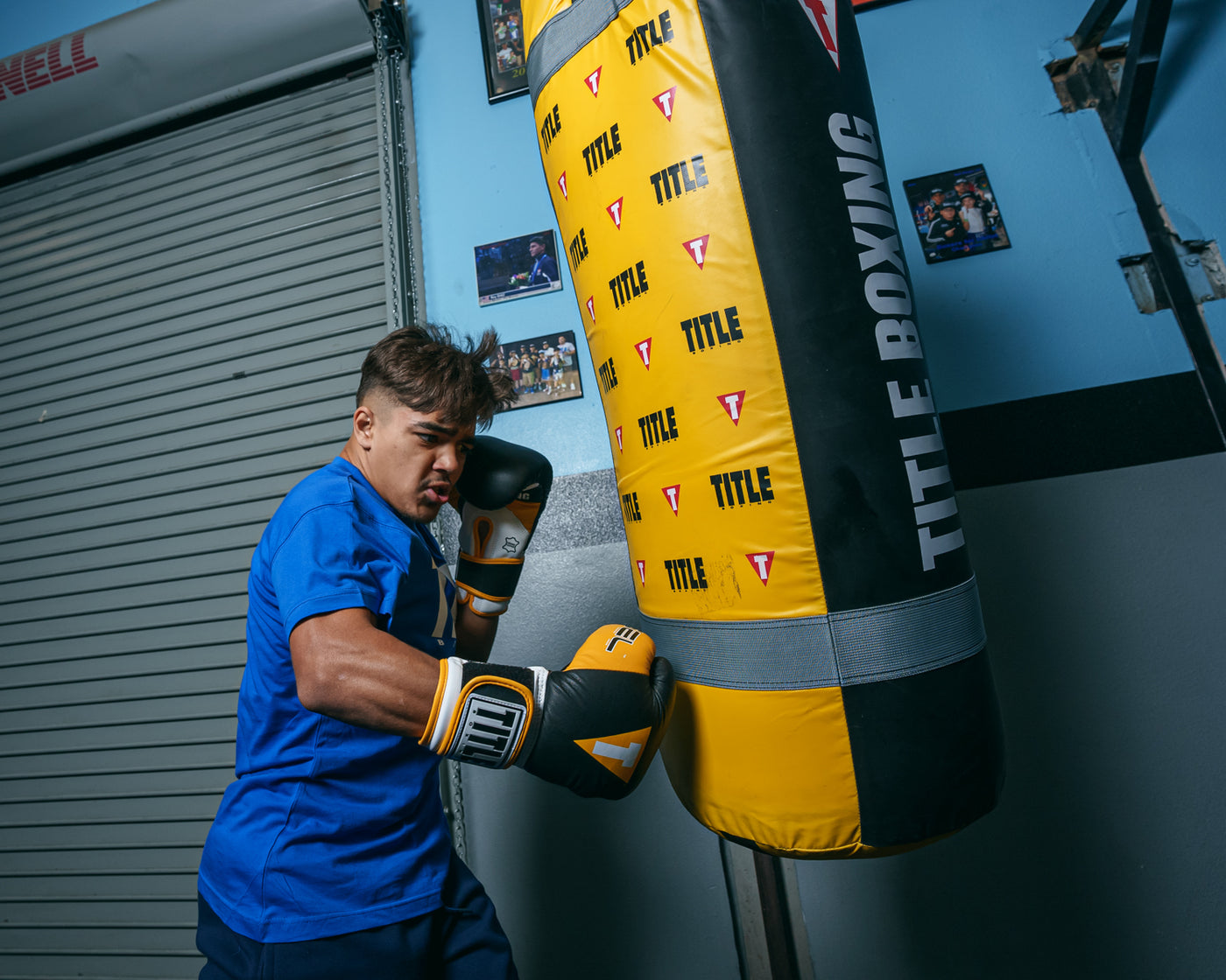 variant:black/gold::TITLE Boxing Gel World V2T Bag Glove guy hitting bag right jab