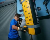 variant:black/gold::TITLE Boxing Gel World V2T Bag Glove guy hitting bag right jab