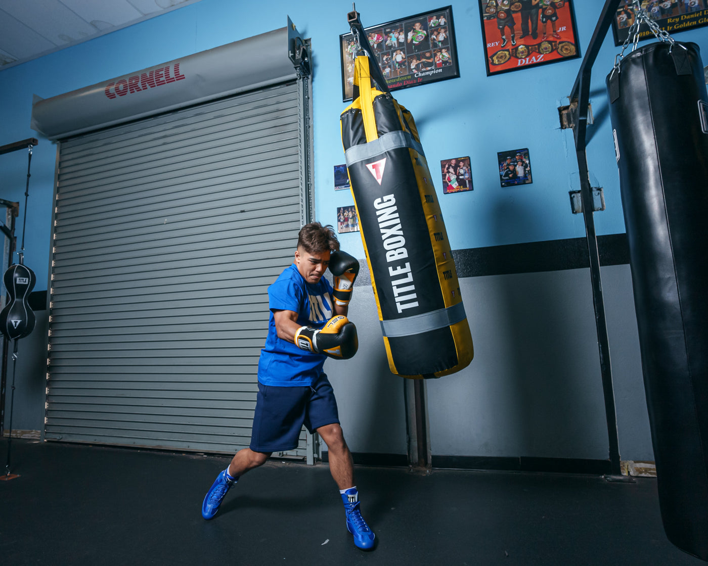 variant:black/gold::TITLE Boxing Gel World V2T Bag Glove guy hitting bag right jab long shot